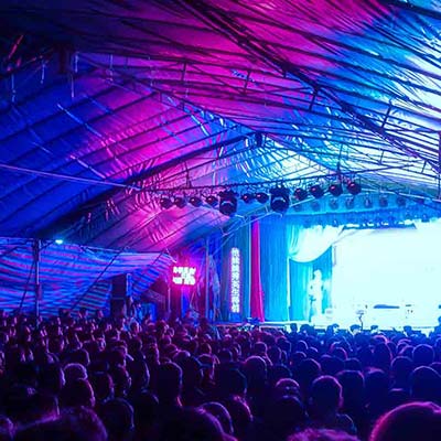 Guests attending a corporate event about to watch a band at a stage lit up with coloured lights