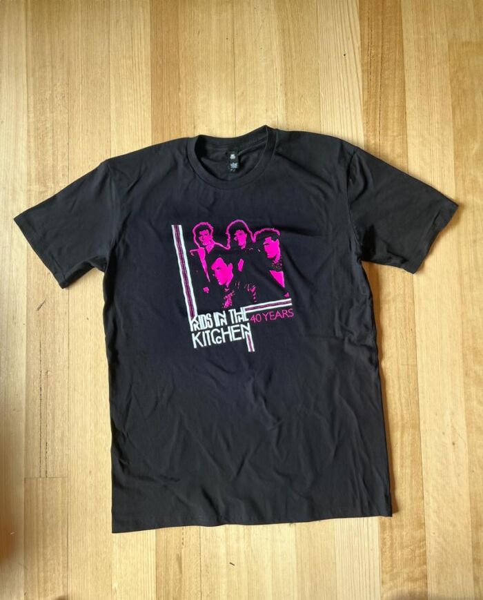 Kids In The Kitchen 40 years shirt with pink and white print of the band on